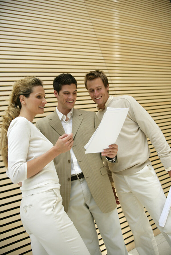 三个看着文件面带微笑的白领精英图片图片