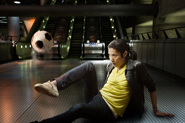 在电梯前玩足球的时尚青年图片