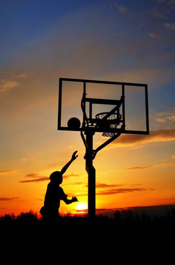 夕阳下投篮的运动员图片