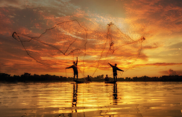 晚霞撒网的渔民图片