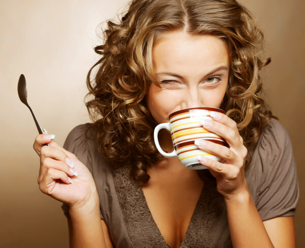 正在喝咖啡的卷发美女图片