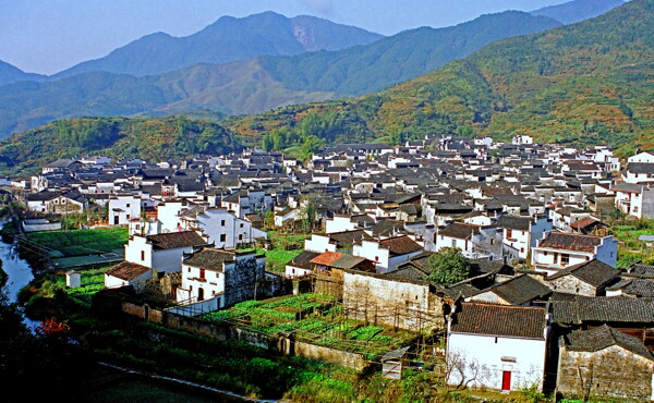 陽光下連綿的青山和錯落有致的鄉(xiāng)村建筑風光