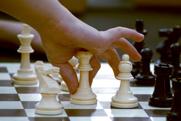 一個人正在冷靜思考移動國際象棋棋子