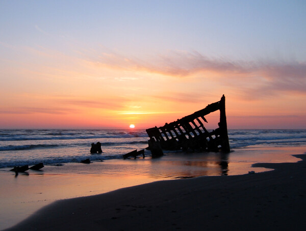 海滩沉船夕阳图片