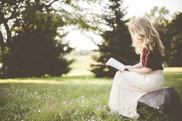 坐在石头上看书的女孩