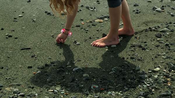 女孩捡起卵石Beach