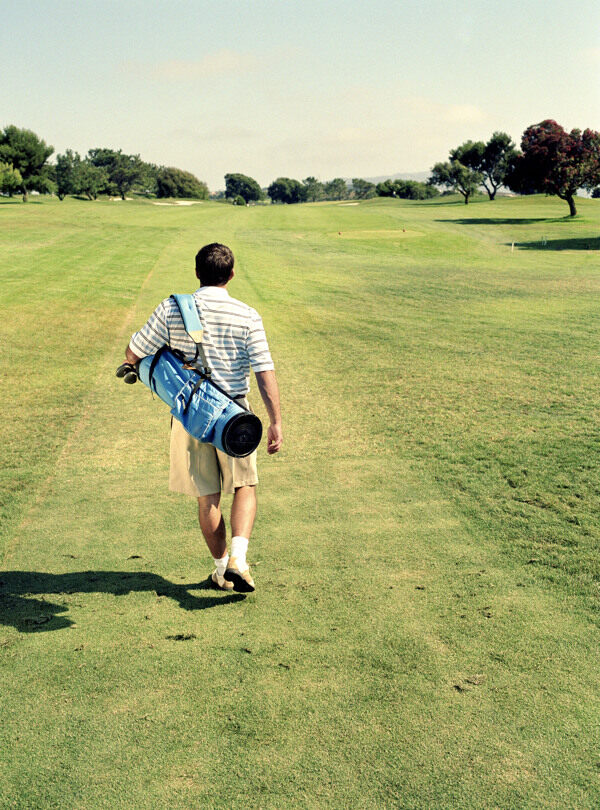 背着高尔夫球具的男人背影图片