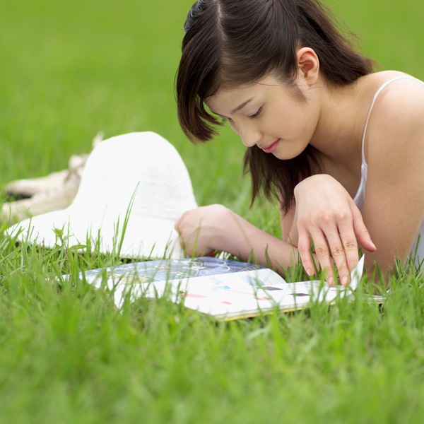 趴草地上看书的美女图片