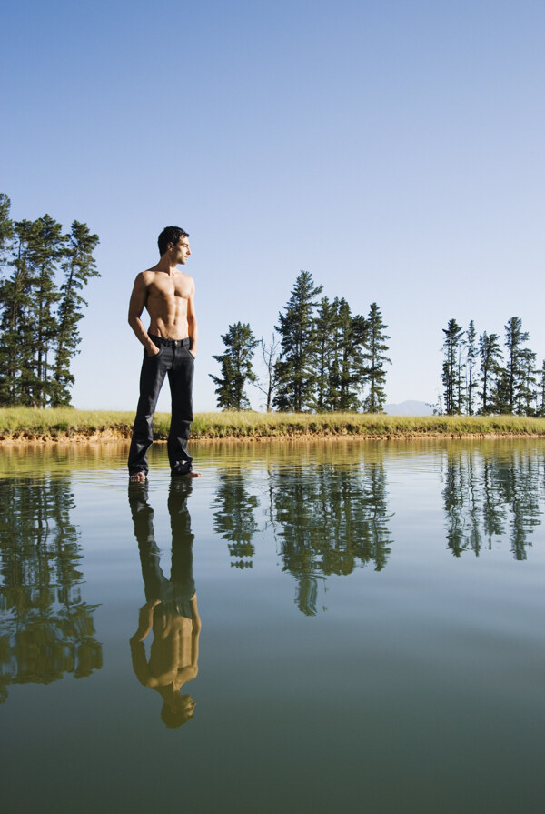 站立在水面上看向远方的男人图片
