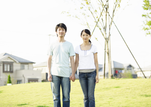 手牵手站在草坪上的青年夫妻图片