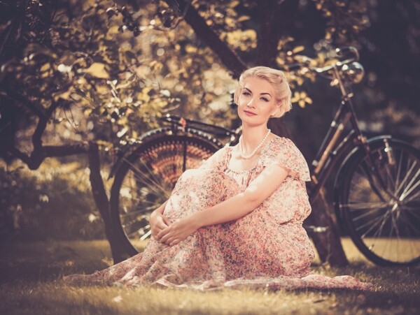 坐在树下的复古美女和自行车图片
