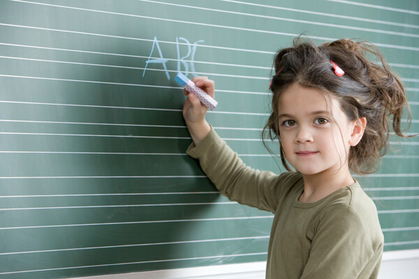在黑板上写粉笔字的小女孩图片