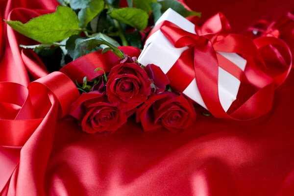 红色丝绸上的礼品盒图片