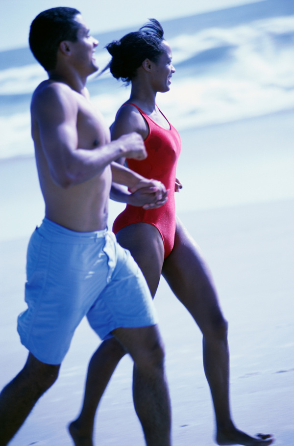沙滩上的跑步的外国男女图片